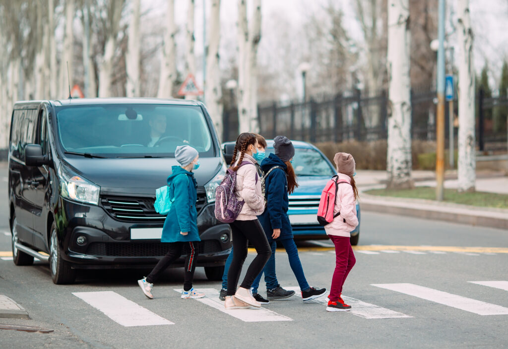 kids walking to school across a crosswalk