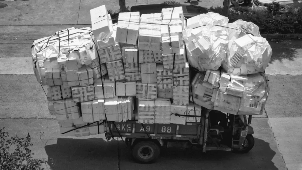 Overly loaded truck with its cargo poorly secured.