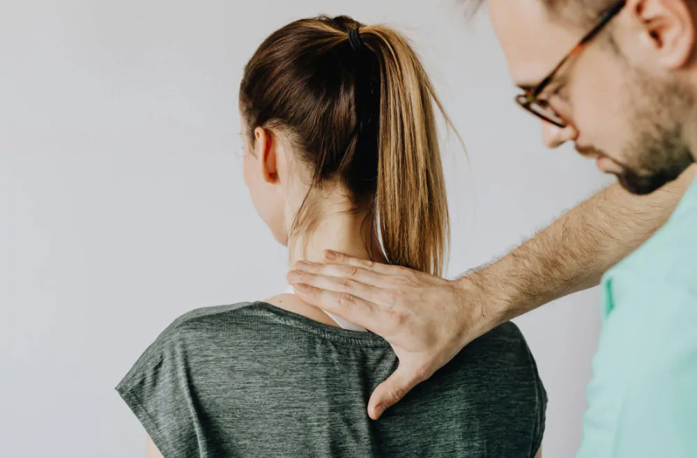 Healthcare professional examining a patient with a back injury.